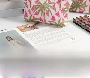 Nahaufnahme der Palmenstickerei auf einer beigefarbenen Canvas-Kosmetiktasche im Lifestyle