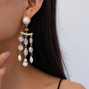 Close-up of vintage gold tassel earrings with pearls and crystals on a model