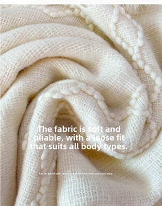 Close-up of thick beige knit fabric with soft texture and wave-like weave patterns