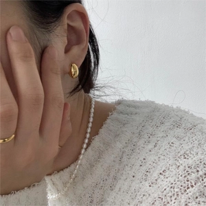 Minimalist gold bean earrings and pearl necklace set on model with knit sweater