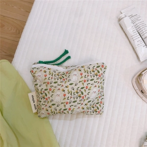 Detail of floral cotton mini pouch with white poodle print and green zipper pull cord