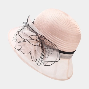 Detail of elegant pink organza flower with black mesh on a wide-brim sun hat