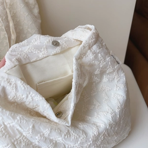 Macro detail of French lace embroidery cotton tote with magnetic closure and inner pocket