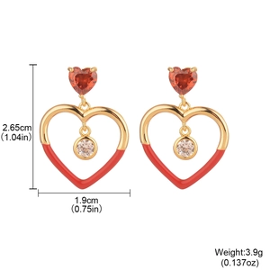 Elegant gold heart earrings with red enamel and clear cubic zirconia on white background