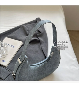 Detailed top view of grey denim hobo bag with silver zipper and sturdy strap