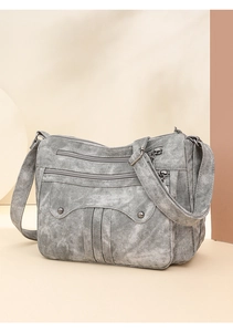 Detailed view of grey washed texture and multi-layer zipper pockets on the crossbody bag