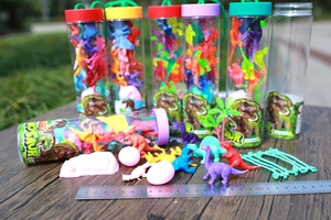 Macro view of assorted plastic dinosaur figurines and accessories with a measuring ruler