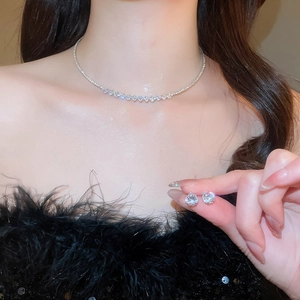 Detail of silver V-shaped pearl necklace and rhinestone earrings on elegant model