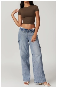 Detail shot of blue wide-leg jeans with flipped waistband and distressed ripped details