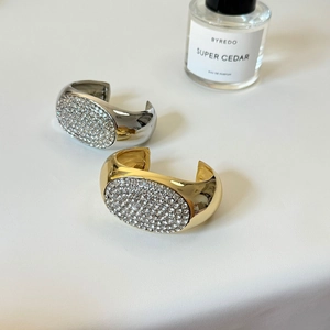 Auffälliger breiter ovaler Armreif mit glitzernden Kristallen in Gold und Silber Optik