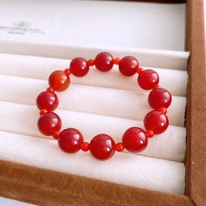 Detailed close-up of red agate beaded bracelet in a white jewelry gift box