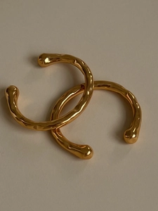 Dettaglio degli orecchini a clip placcati oro 18K con trama lavica irregolare per donna