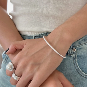 Bracelet minimaliste en argent sterling 925 avec texture feuille sur le poignet d'une femme
