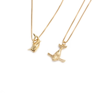 Minimalist gold plated copper dolphin and narwhal pendant necklaces on white background