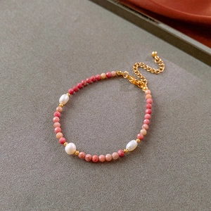 Detail of beaded bracelet with pink faceted rhodochrosite stones and freshwater pearls
