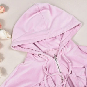 Detail of pink velvet hoodie showing soft texture and silver metal zipper closure
