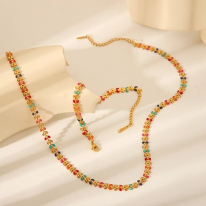 Detailed view of gold olive leaf necklace and bracelet set with colorful enamel finish