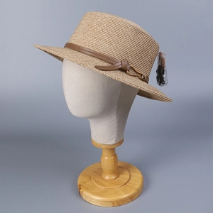 Vue détaillée du chapeau de paille tissé avec ruban en cuir marron et boucle métallique