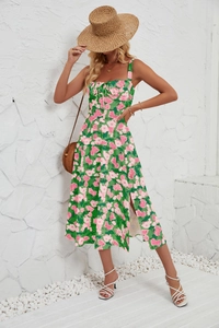 Detail of green floral midi dress with side slit and drawstring front on a stone wall backdrop