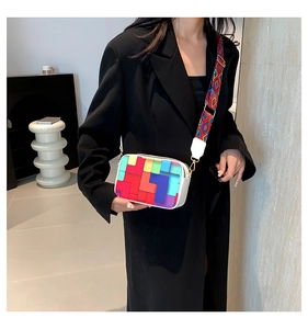 Close-up of colorful geometric patchwork handbag with ethnic patterned wide strap