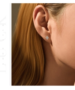Gros plan d'un mannequin portant des boucles d'oreilles en argent serties de diamants