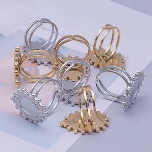 Close-up of DIY gold and silver stainless steel oval ring bases with scalloped edges