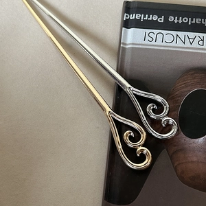 Elegant gold and silver Ruyi metal hairpins with hollow cloud motifs on a book