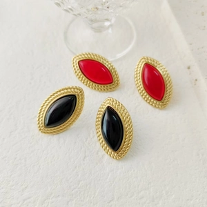 Detail of vintage eye-shaped earrings in red and black with gold woven texture