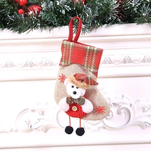 Detailed view of beige linen Christmas stocking with plush white bear and red snowflake motif