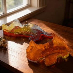 Figurines de chat en résine avec paillettes sur un rebord de fenêtre en bois ensoleillé