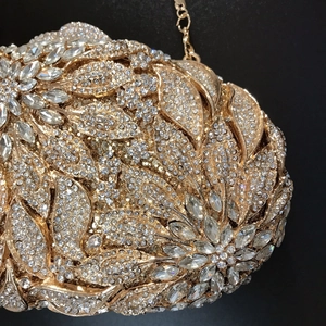 Macro shot of gold floral evening bag featuring intricate crystal and rhinestone settings