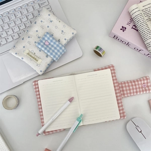 Flat lay of floral cloth journal cover set with pink grid notebook and matching pen bag