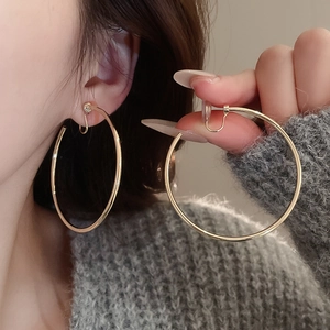 Model wearing large gold minimalist hoop earrings with elegant minimalist circular design