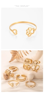 Detailed flat lay of assorted gold-plated geometric oval open bangles on a white background