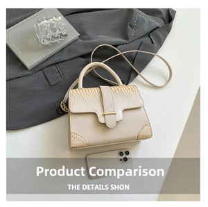 Detail der beigen Handtasche mit Krokodilprägung, Goldschnalle und Smartphone zum Größenvergleich