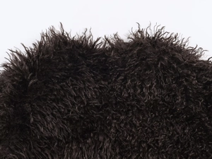 Close-up of curly black faux fur texture showing dense plush material for winter coats