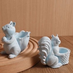 Detail of blue squirrel resin storage jars with 3D texture on a wooden stand