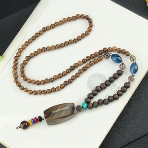 Vintage ethnic style long wood bead necklace with striped agate pendant on a black background