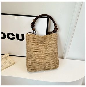 Detailed view of the woven straw bucket bag texture and dark wooden bead handle