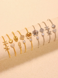 Macro shot of stainless steel open bangles with zircon starfish and shell motifs