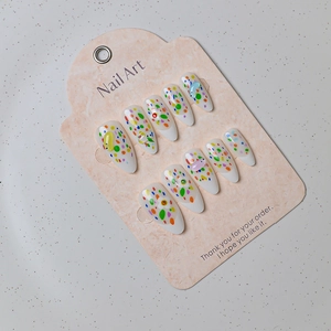 Detailed close-up of almond-shaped press-on nails with 3D colorful polka dots and gems
