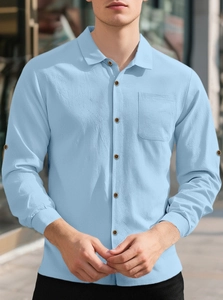 Detail of light blue linen shirt featuring textured waffle fabric and wood buttons