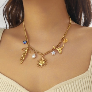 Gold multi-pendant necklace featuring blue heart, bow, and bull head charms on a chain