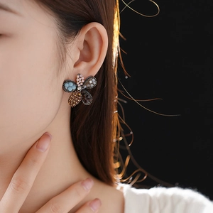 Detailed view of a multi-colored floral stud earring featuring vibrant crystals and rhinestones