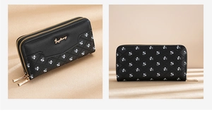 Detail of black long wallet with double zippers, floral pattern, and metal logo on silk
