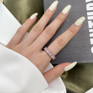 Detailed view of a square-cut pink gemstone ring with silver band on a model hand