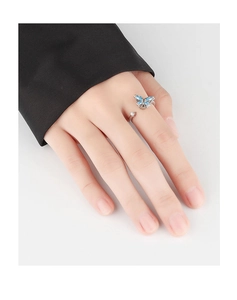 Close-up of adjustable silver butterfly ring with blue gemstone on model hand