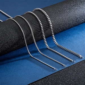 Detail of four silver stainless steel box chains in various thicknesses on blue background