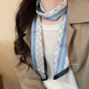 Detail of blue striped twilly scarf necklace on a trench coat for an elegant look