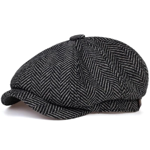Detail of grey herringbone newsboy cap showing octagonal stitching and classic wool texture